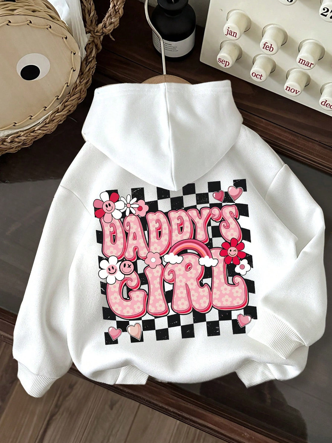 This hooded sweatshirt is perfect for young girls during autumn and winter. It features a cute plaid floral heart design with a printed letter, adding a touch of style to any outfit. Stay warm and stylish this season with this must-have piece.