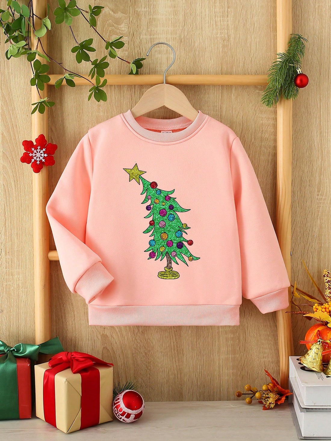 Add a touch of festive charm to your young girl's wardrobe with this cute sweatshirt. Featuring a sequin Christmas tree graphic, it adds a fun and stylish element to her outfit. Made from fleece material, it guarantees warmth and comfort during the holiday season. Perfect for spreading holiday cheer!